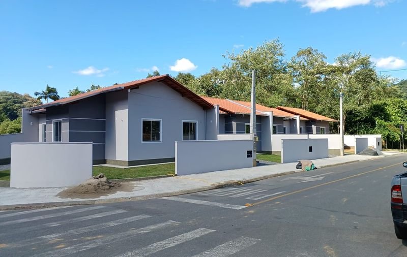 Casas geminadas pintadas em cinza com faixas brancas, vistas da esquina