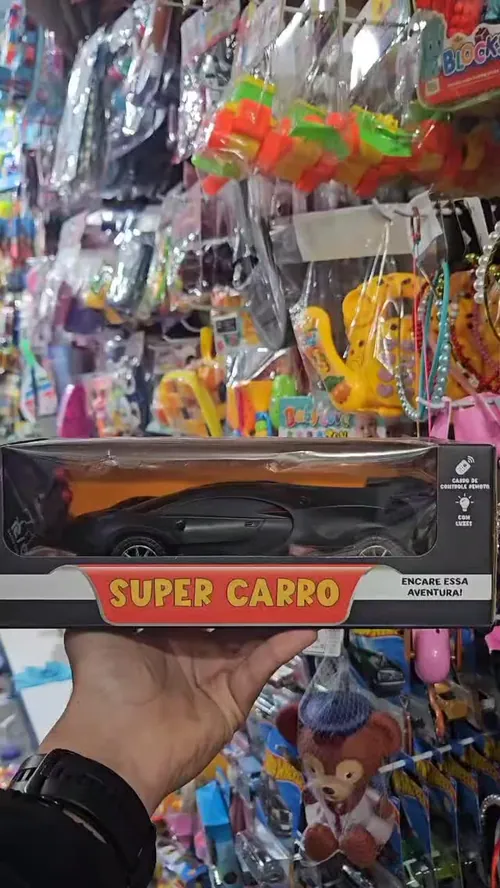 Mão segurando a caixa de um carrinho de controle remoto na loja