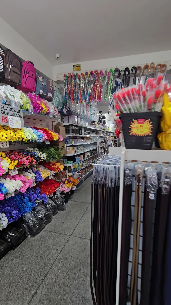 Corredor com flores artificiais coloridas e cintos pendurados