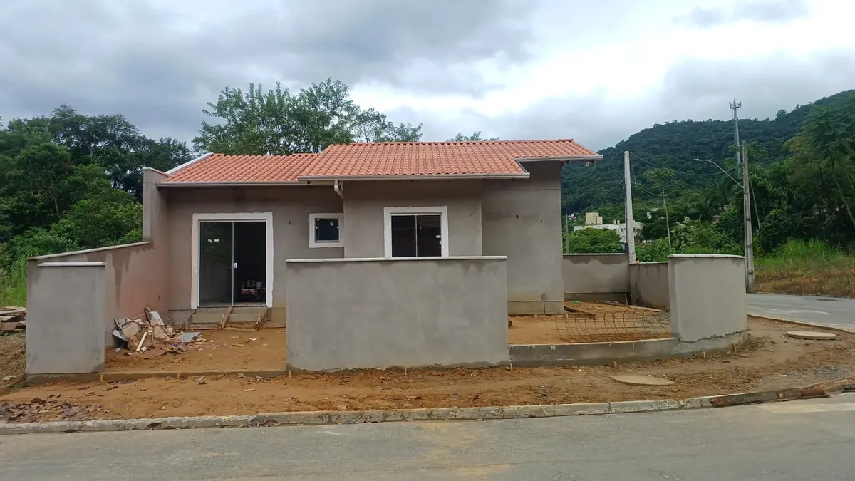 Casa geminada com muro e paredes ainda sem acabamento